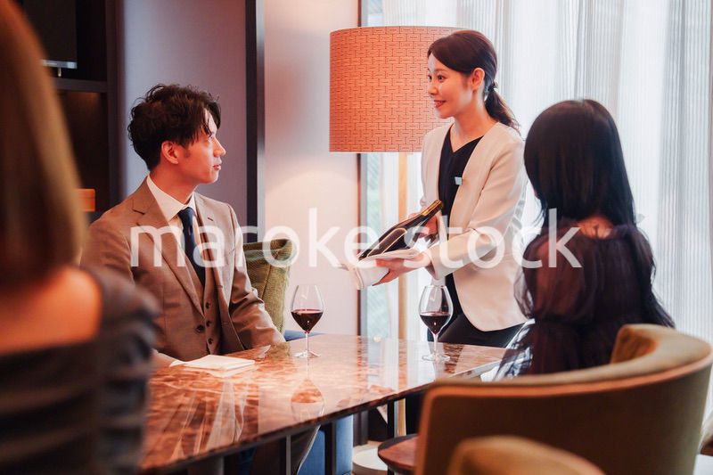 ワインをお客様におすすめをする女性のスタッフ