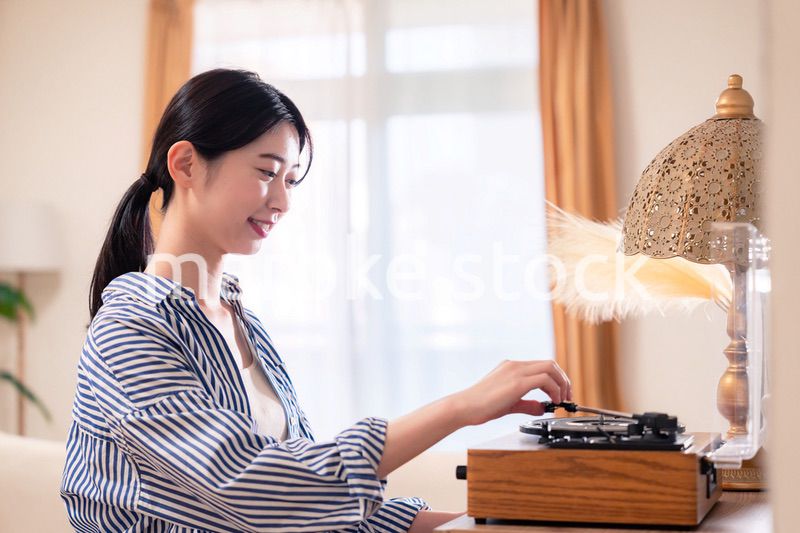 家でレコードを聴く若い女性