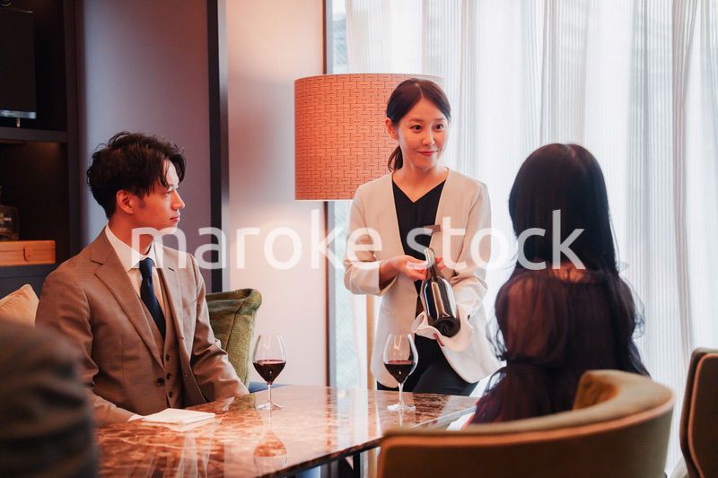 ワインをお客様におすすめをする女性のスタッフ