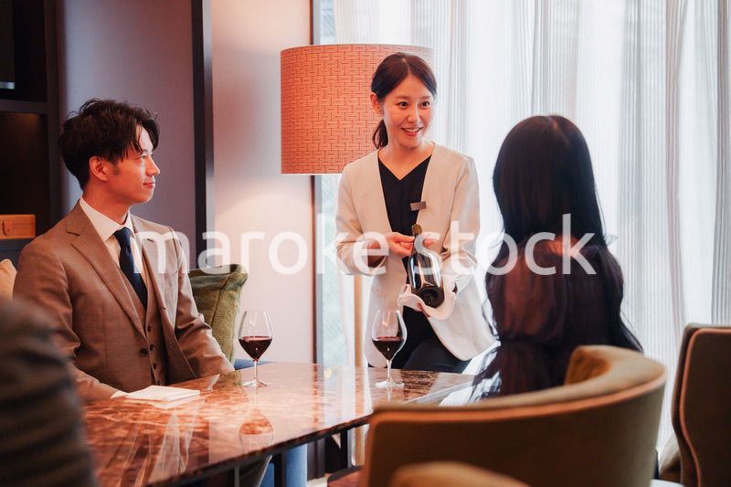 ワインをお客様におすすめをする女性のスタッフ