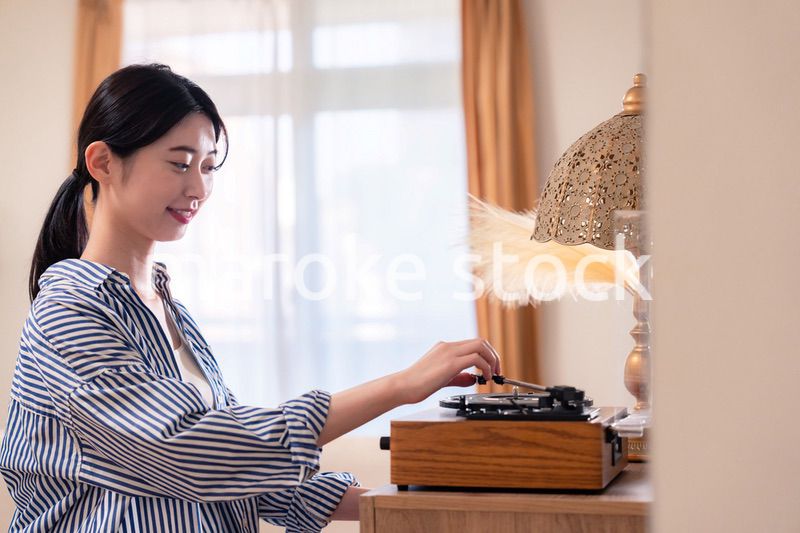 家でレコードを聴く若い女性
