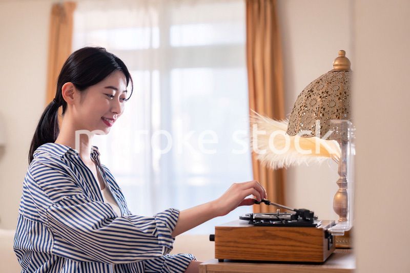 家でレコードを聴く若い女性