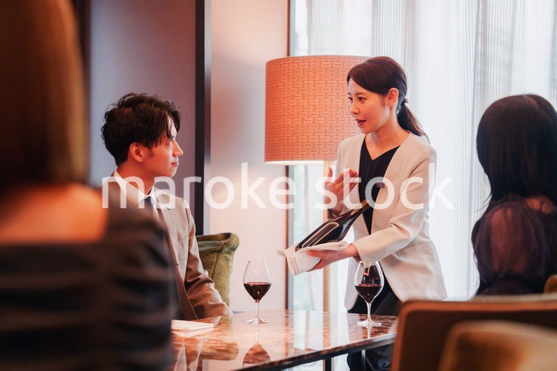 ワインをお客様におすすめをする女性のスタッフ