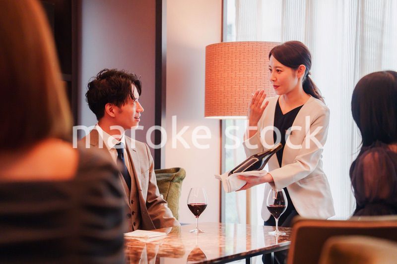 ワインをお客様におすすめをする女性のスタッフ
