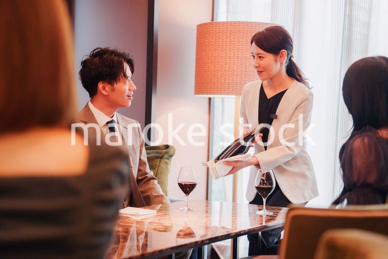 ワインをお客様におすすめをする女性のスタッフ