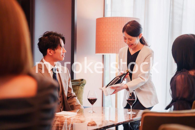 ワインをお客様におすすめをする女性のスタッフ