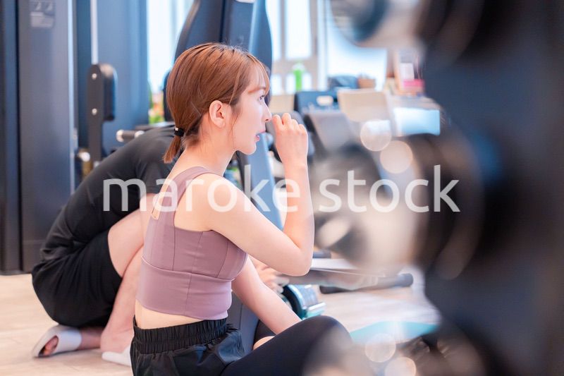 パーソナルジムに通う女性とトレーナー