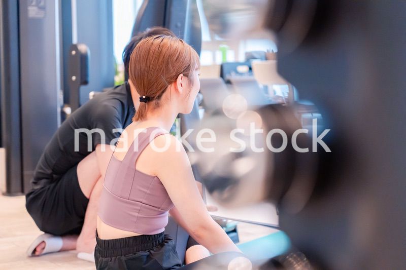 パーソナルジムに通う女性とトレーナー
