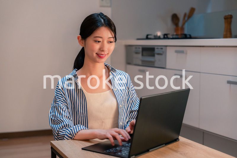 夜遅くまで在宅勤務をする若い女性