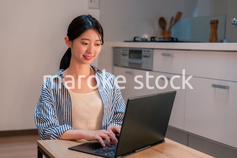 夜遅くまで在宅勤務をする若い女性