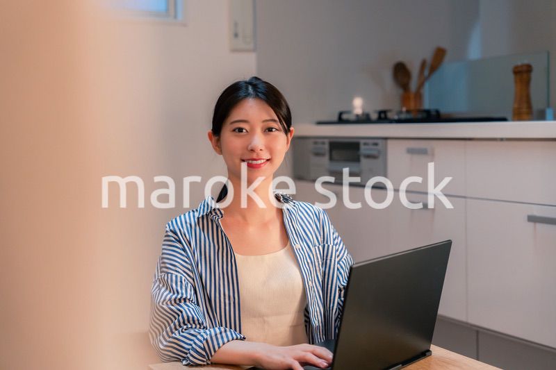 夜遅くまで在宅勤務をする若い女性