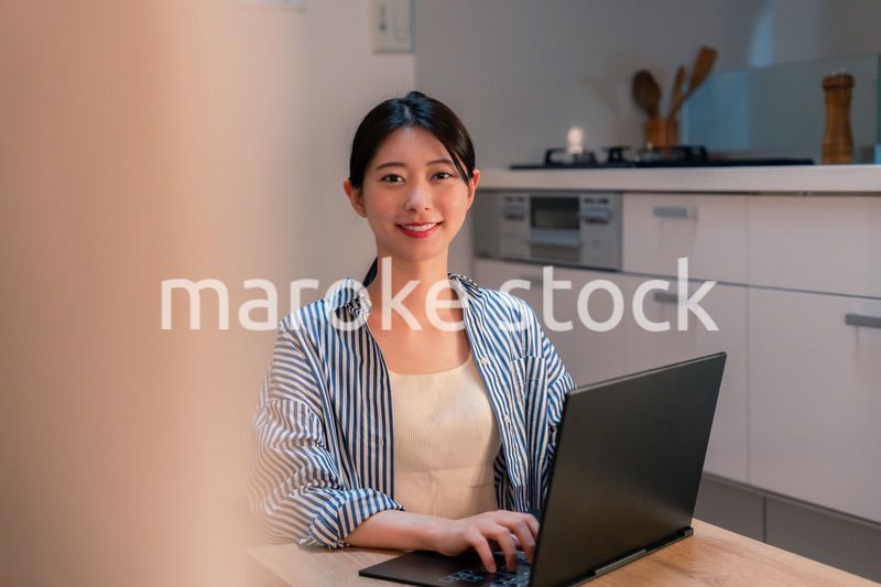 夜遅くまで在宅勤務をする若い女性