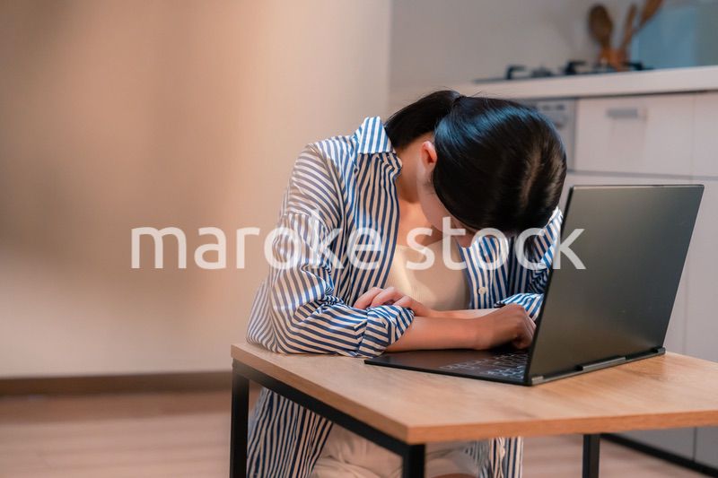 長時間の在宅勤務で疲労をする若い女性