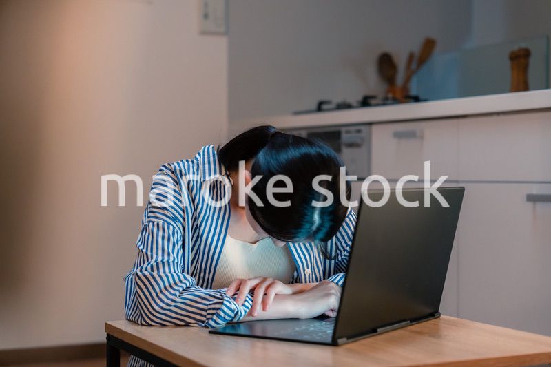 長時間の在宅勤務で疲労をする若い女性