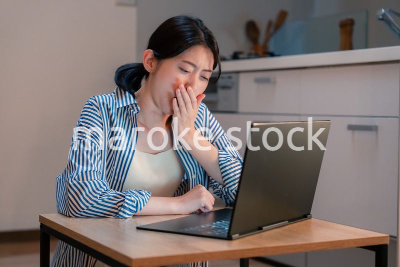 長時間の在宅勤務で疲労をする若い女性