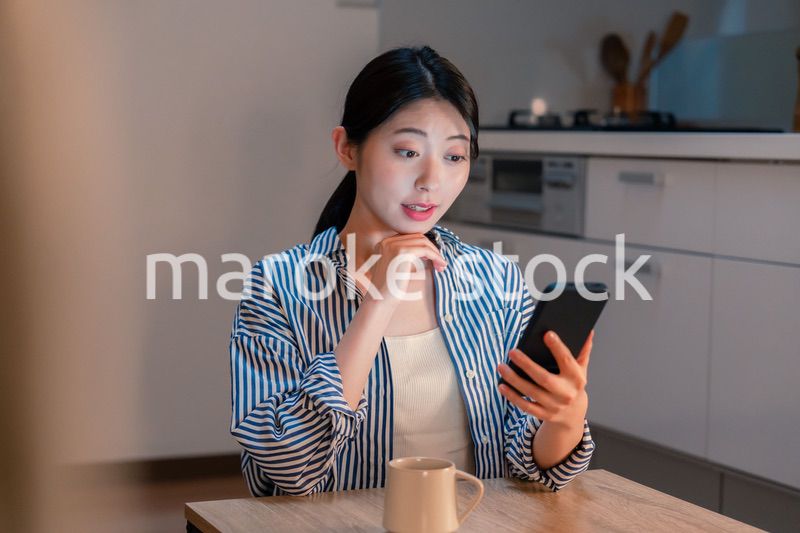 夜遅くに笑顔でスマホを使う若い女性