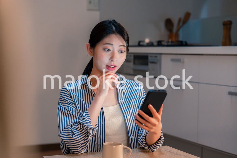 夜遅くに笑顔でスマホを使う若い女性