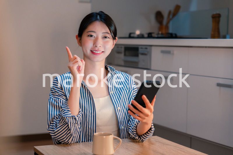 夜遅くに笑顔でスマホを使う若い女性