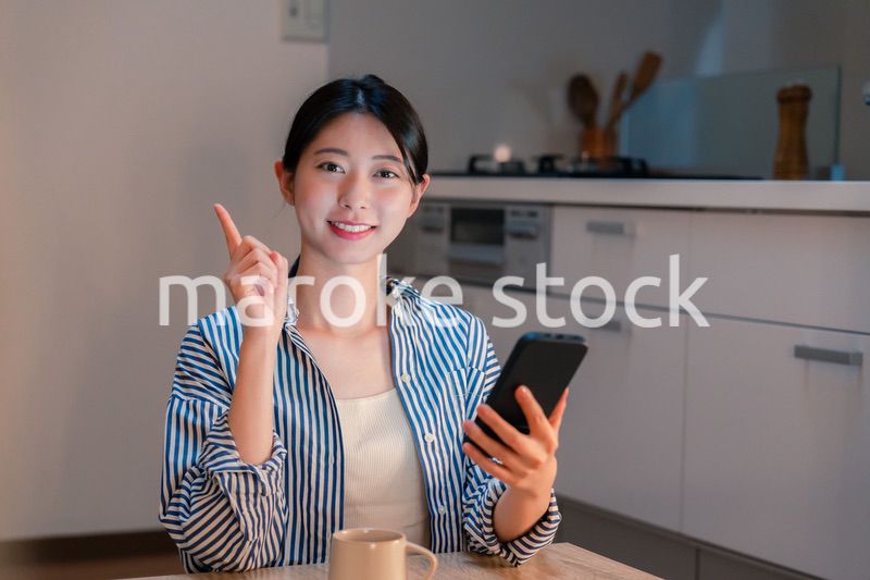 夜遅くに笑顔でスマホを使う若い女性