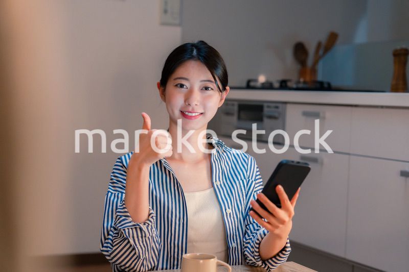 夜遅くに笑顔でスマホを使う若い女性