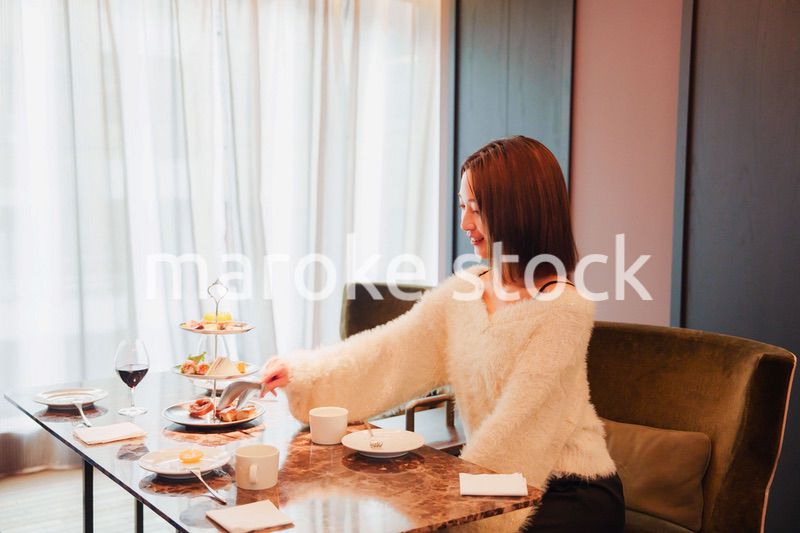 ホテルのラウンジで食事を楽しむ若い女性