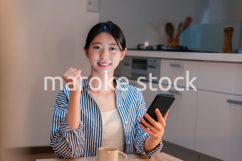 夜遅くに笑顔でスマホを使う若い女性