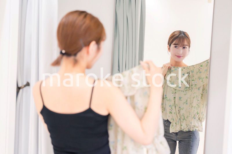 試着室で服の試着をする若い女性