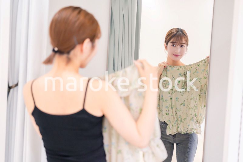 試着室で服の試着をする若い女性