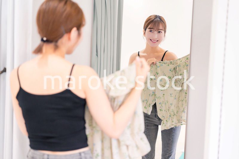 試着室で服の試着をする若い女性