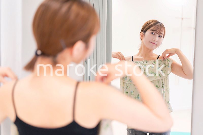 試着室で服の試着をする若い女性