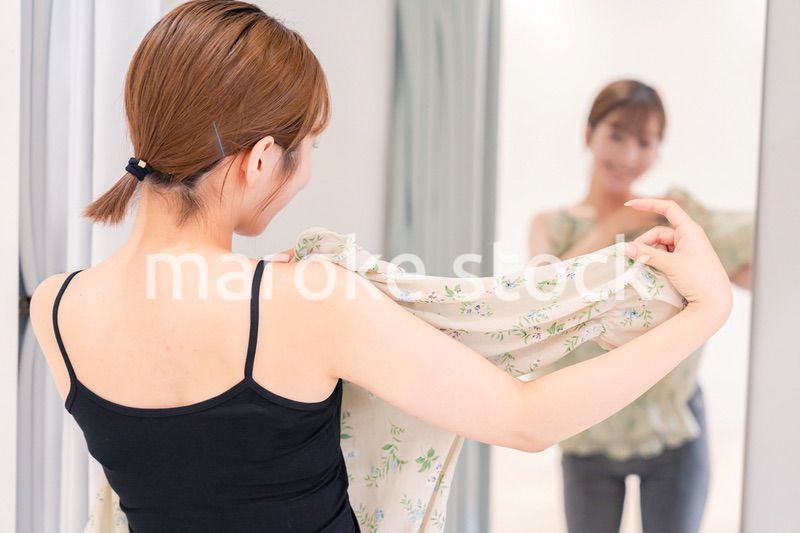 試着室で服の試着をする若い女性