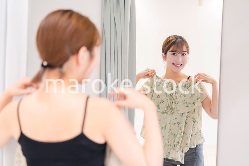 試着室で服の試着をする若い女性