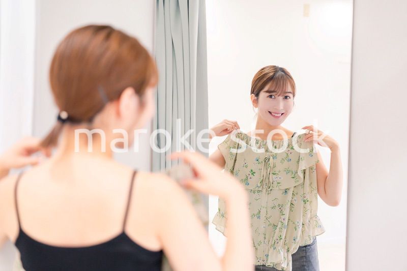 試着室で服の試着をする若い女性