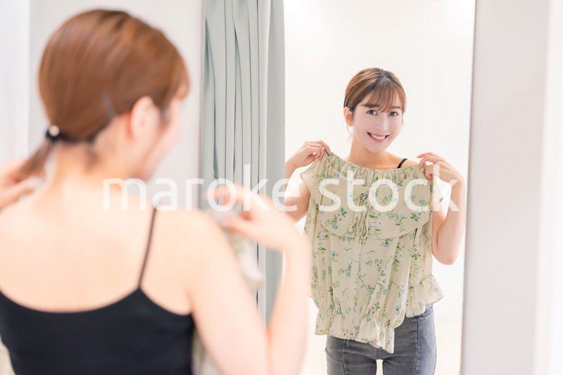 試着室で服の試着をする若い女性
