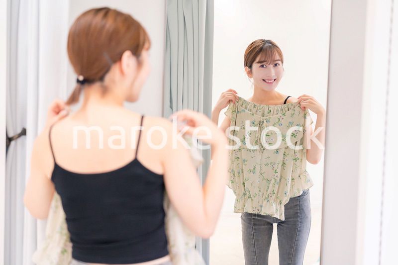 試着室で服の試着をする若い女性