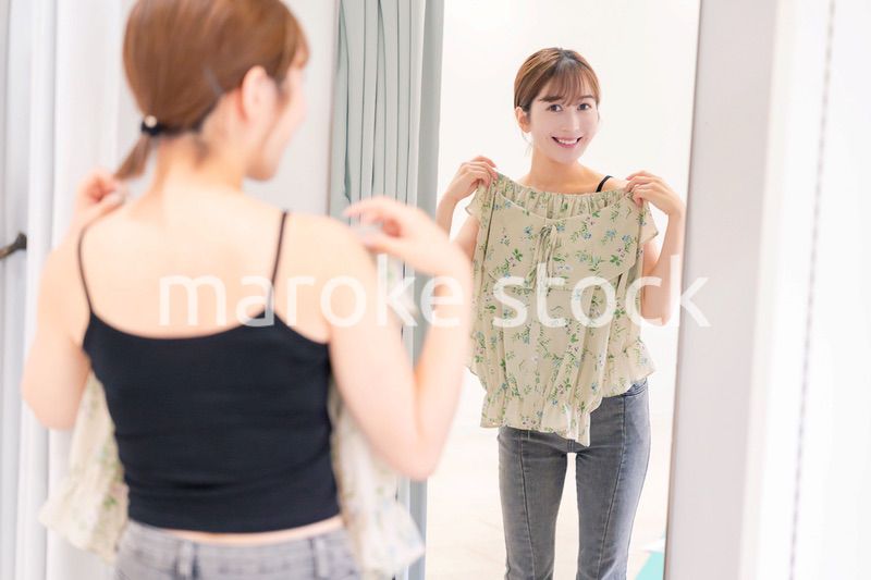 試着室で服の試着をする若い女性