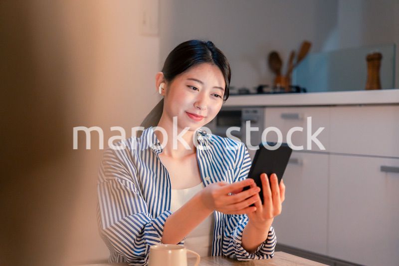 夜にスマホでコンテンツを楽しむ一人暮らしの女性