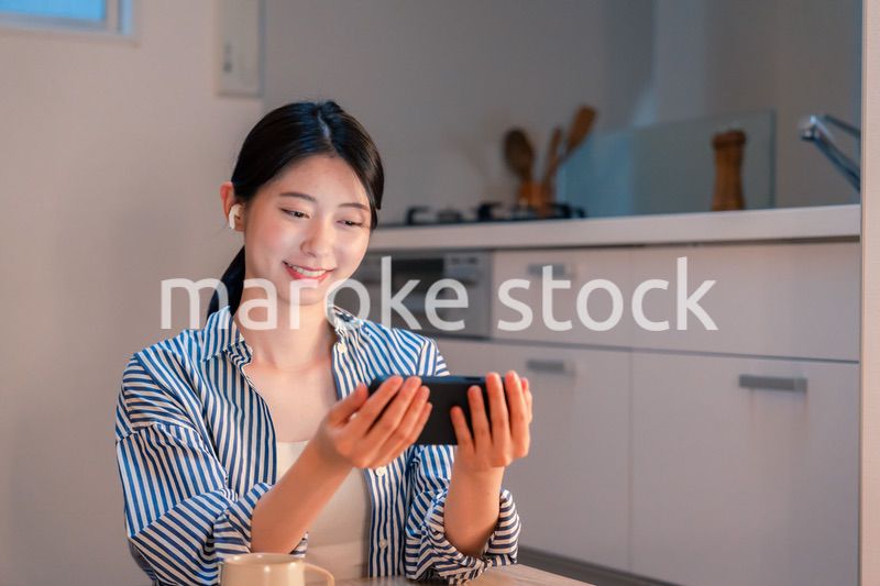 夜にスマホでコンテンツを楽しむ一人暮らしの女性