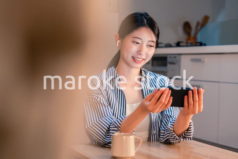 夜にスマホでコンテンツを楽しむ一人暮らしの女性