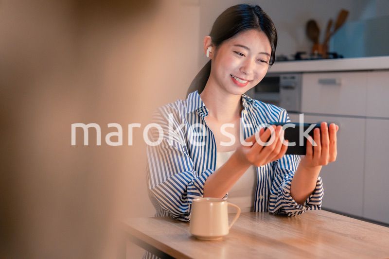 夜にスマホでコンテンツを楽しむ一人暮らしの女性