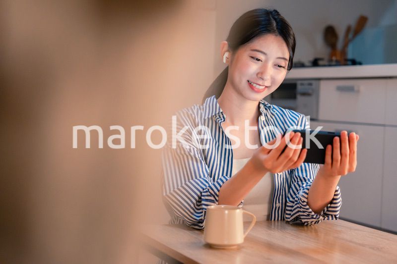 夜にスマホでコンテンツを楽しむ一人暮らしの女性