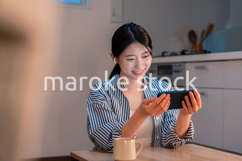 夜にスマホでコンテンツを楽しむ一人暮らしの女性