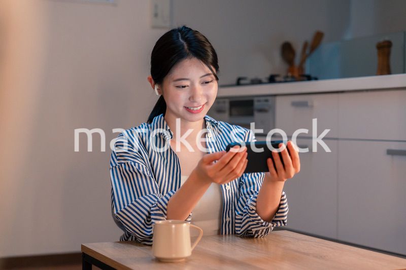 夜にスマホでコンテンツを楽しむ一人暮らしの女性