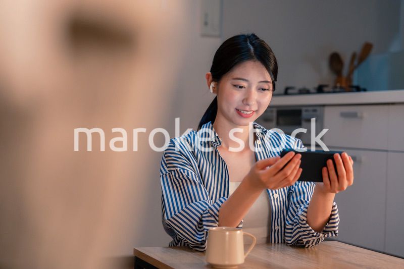 夜にスマホでコンテンツを楽しむ一人暮らしの女性