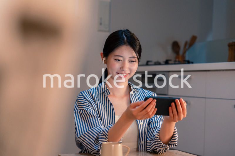 夜にスマホでコンテンツを楽しむ一人暮らしの女性