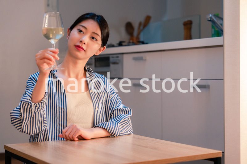 家でワインを楽しむ一人暮らしの女性