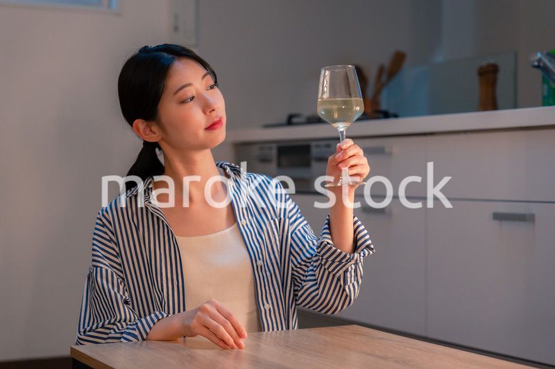 家でワインを楽しむ一人暮らしの女性