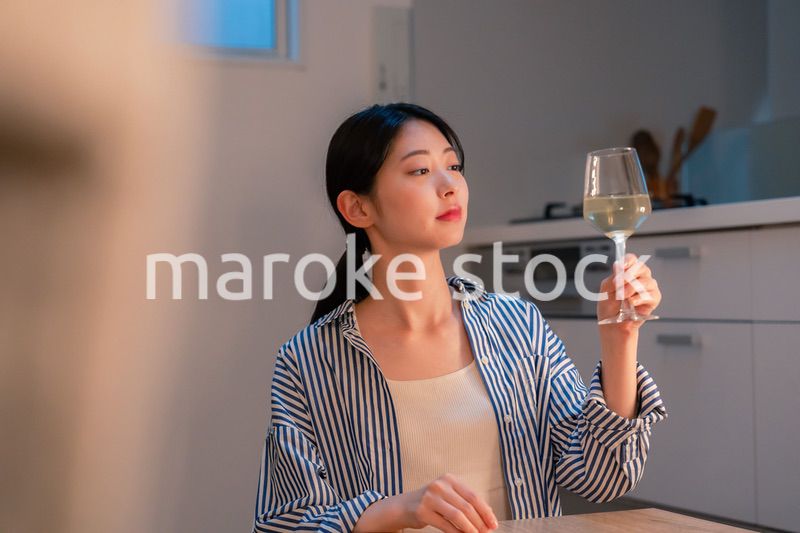 家でワインを楽しむ一人暮らしの女性