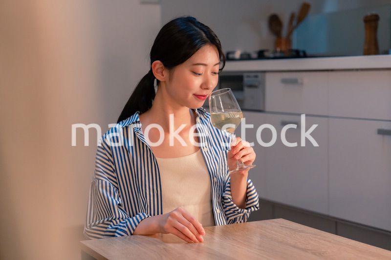 家でワインを楽しむ一人暮らしの女性