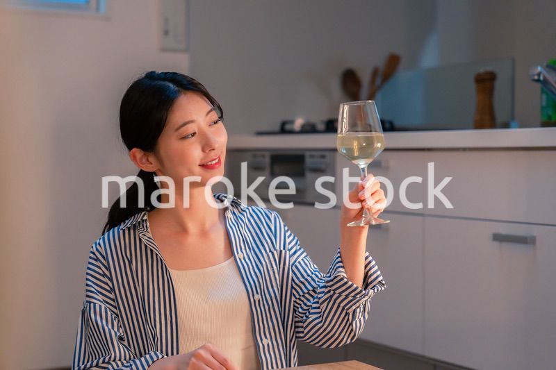家でワインを楽しむ一人暮らしの女性